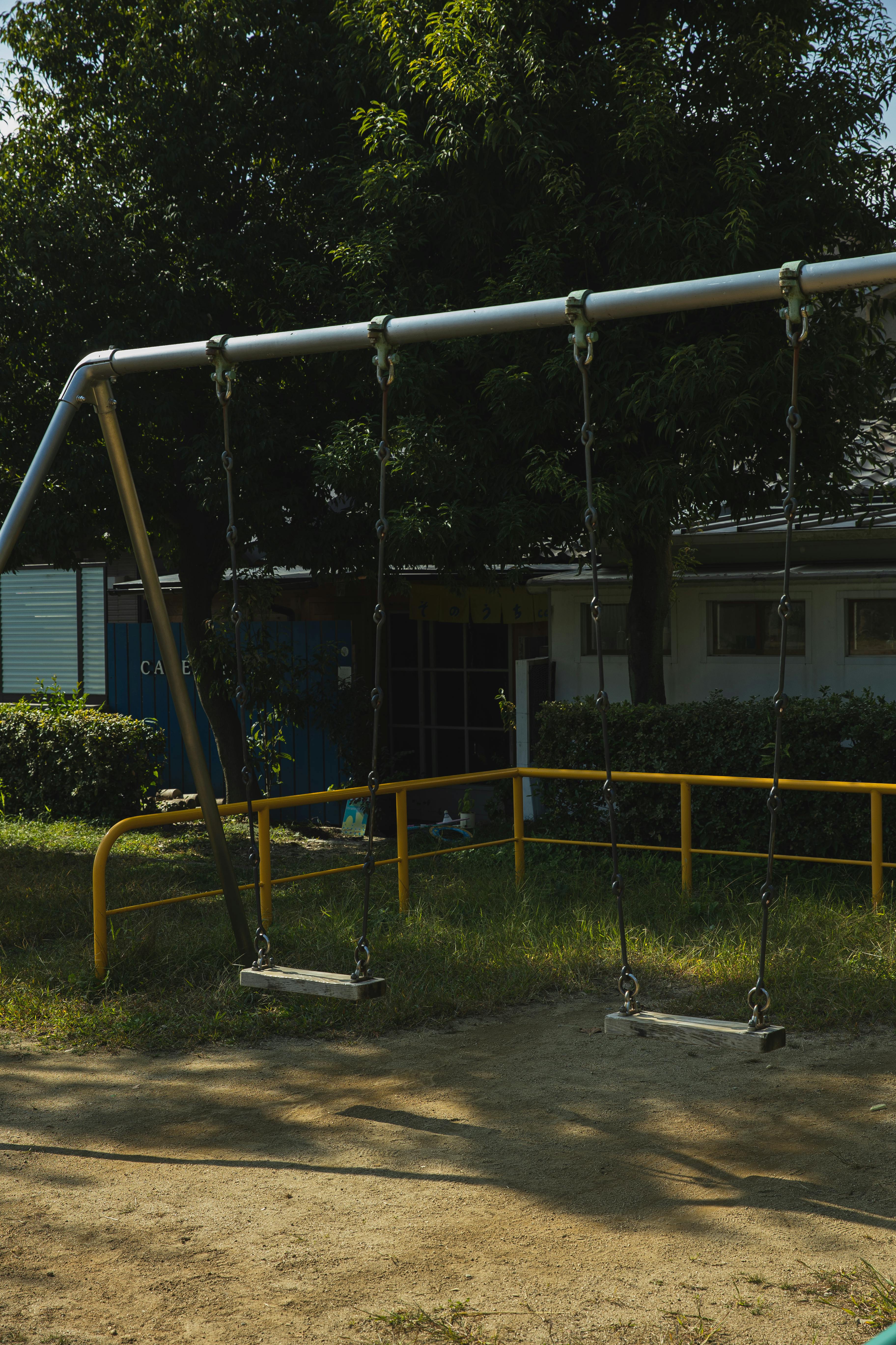 empty swings in yard in summer