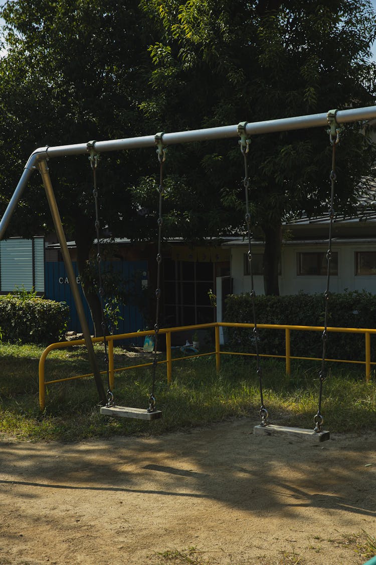 Empty Swings In Yard In Summer