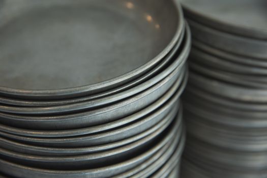 High angle of straight pile of clean metallic bowls on shelf in room