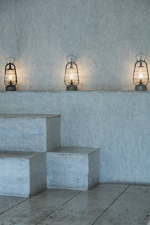 White concrete stairs with bright glowing lamps and shabby wooden floor in house