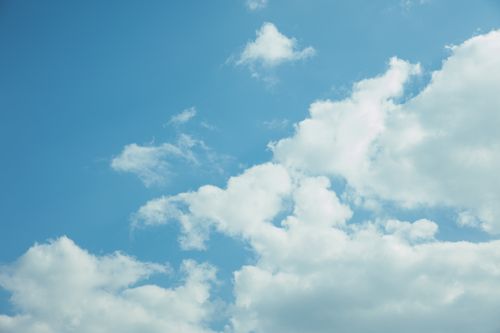 Free Low angle of white fluffy clouds floating in blue sky during windy weather Stock Photo