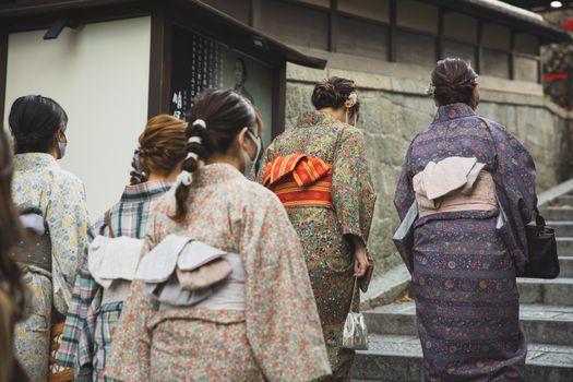 在日本京都，一群身着传统和服的妇女正走过街道