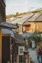 Authentic wooden houses on narrow paved street in Asian suburb area under blue sky in daylight