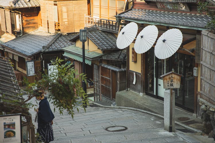 Anonymous Woman Standing On Street In City Historic District In Sunlight