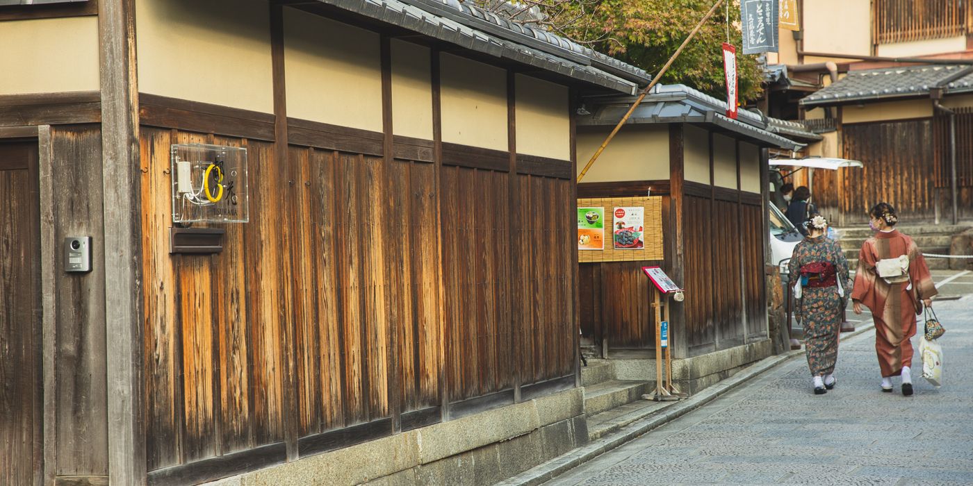 Two people in kimono walking along a traditional street in Kyoto