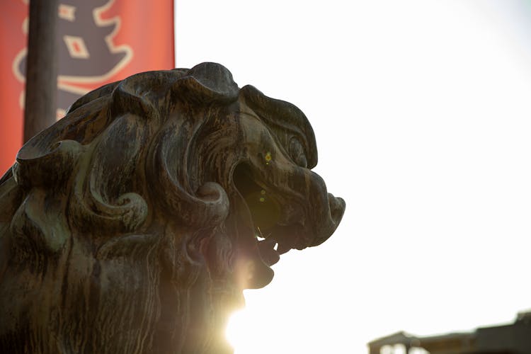 Japanese Lion Dog Statue Near Shrine On Sunny Day