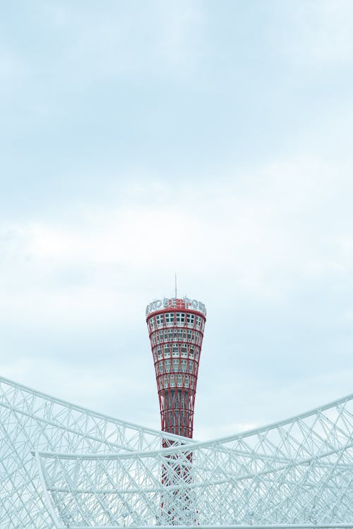 From below of famous Kobe Port Tower located near contemporary geometric building in Japan