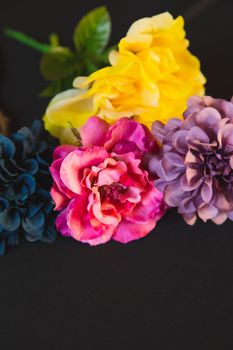 模糊背景上，细茎托着明亮的装饰性花朵，花瓣波浪形，绿叶点缀其间