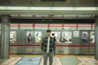 Asian man standing on platform in underground