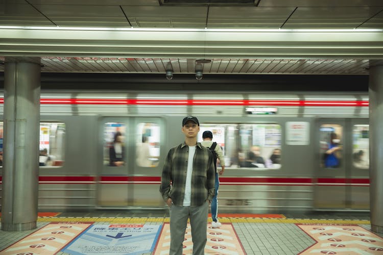 Asian Man Standing On Platform In Underground