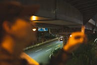 Man with cigarette under road at night