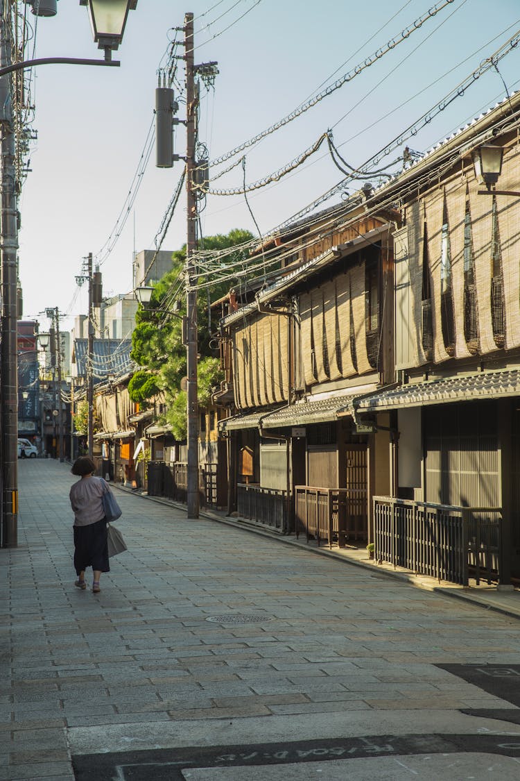 Anonymous Lady Walking Alone On Narrow Street Of Town