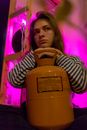 Woman with gas can against neon light