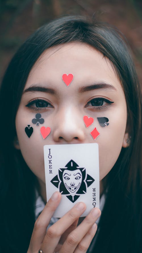 Free A Woman Holding a Playing Card Stock Photo