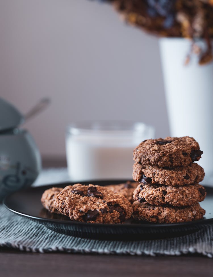 A  Stack Of Chocolate Chip Cookies On Black Plate