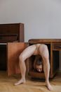 A Contortionist with a Bended Backwards Body in a Wooden Cabinet