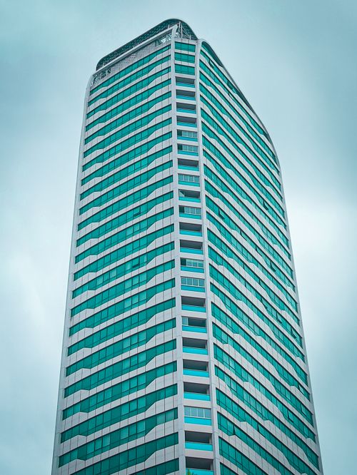 Free Low-angle shot of a modern skyscraper against a cloudy sky in Gaziantep, Turkey. Stock Photo