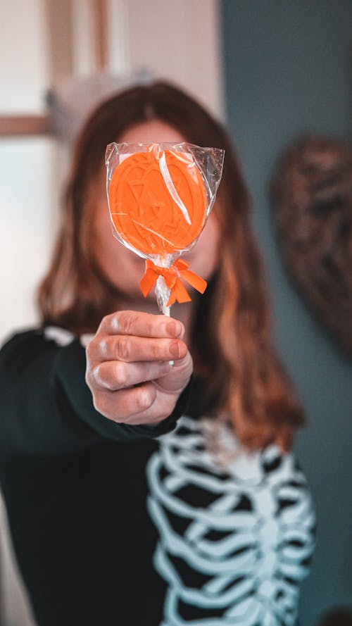 Free A Person Holding a Lollipop Stock Photo