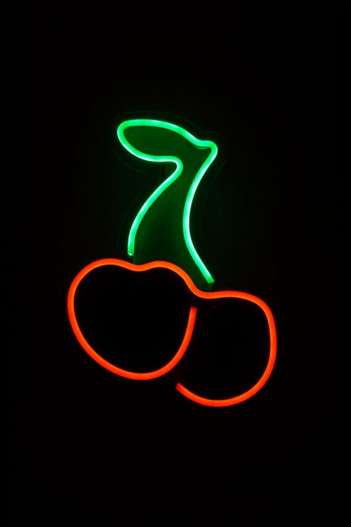 Free Illuminated neon cherry sign glowing against a dark background, perfect for nightlife themes. Stock Photo