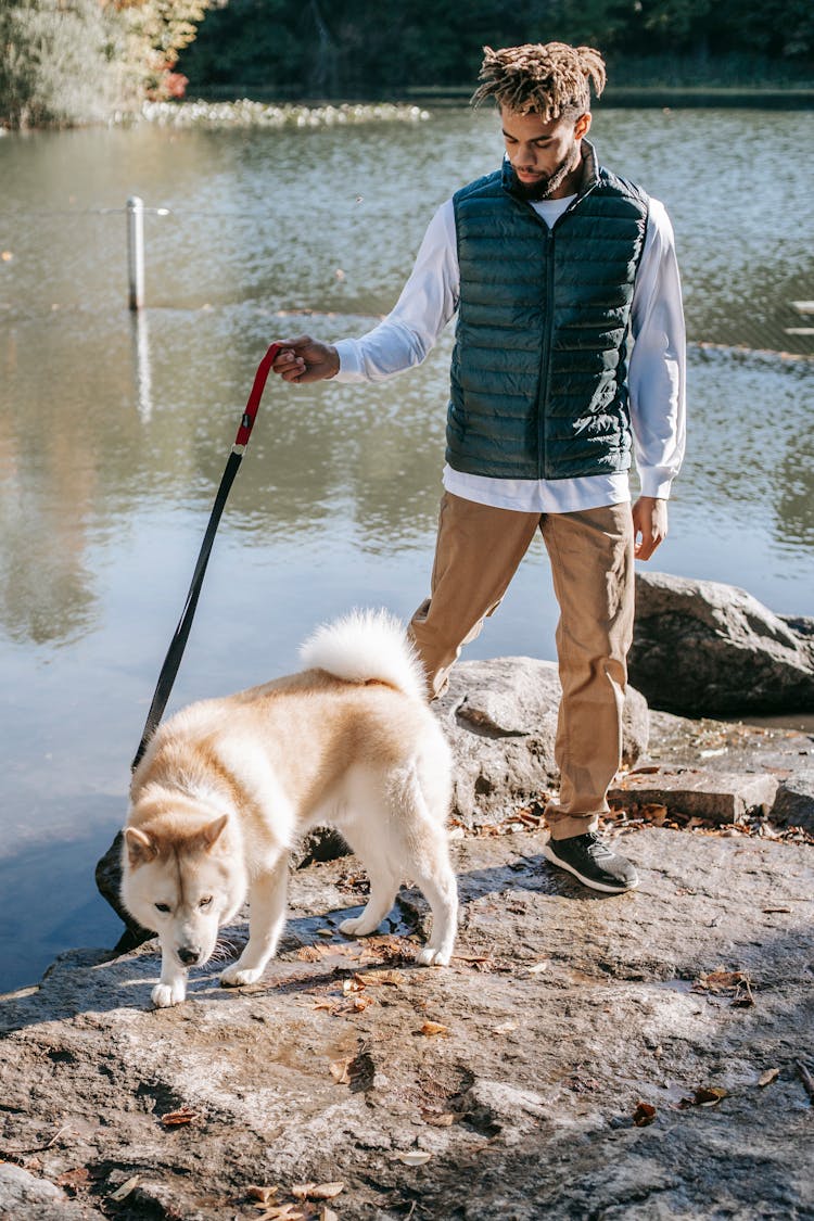 Black Man Walking With Dog Near Lake