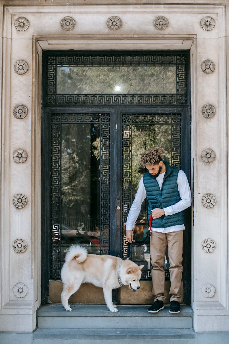 Black Man With Dog At Old Building Doorway