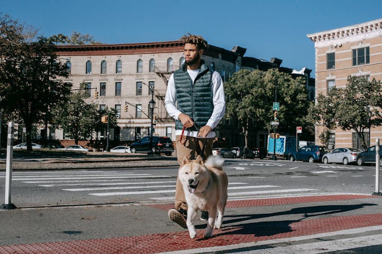 Black Man Crossing Road With Dog