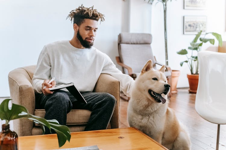 Black Man With Notebook Petting Dog