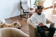 Black man with notebook near dog