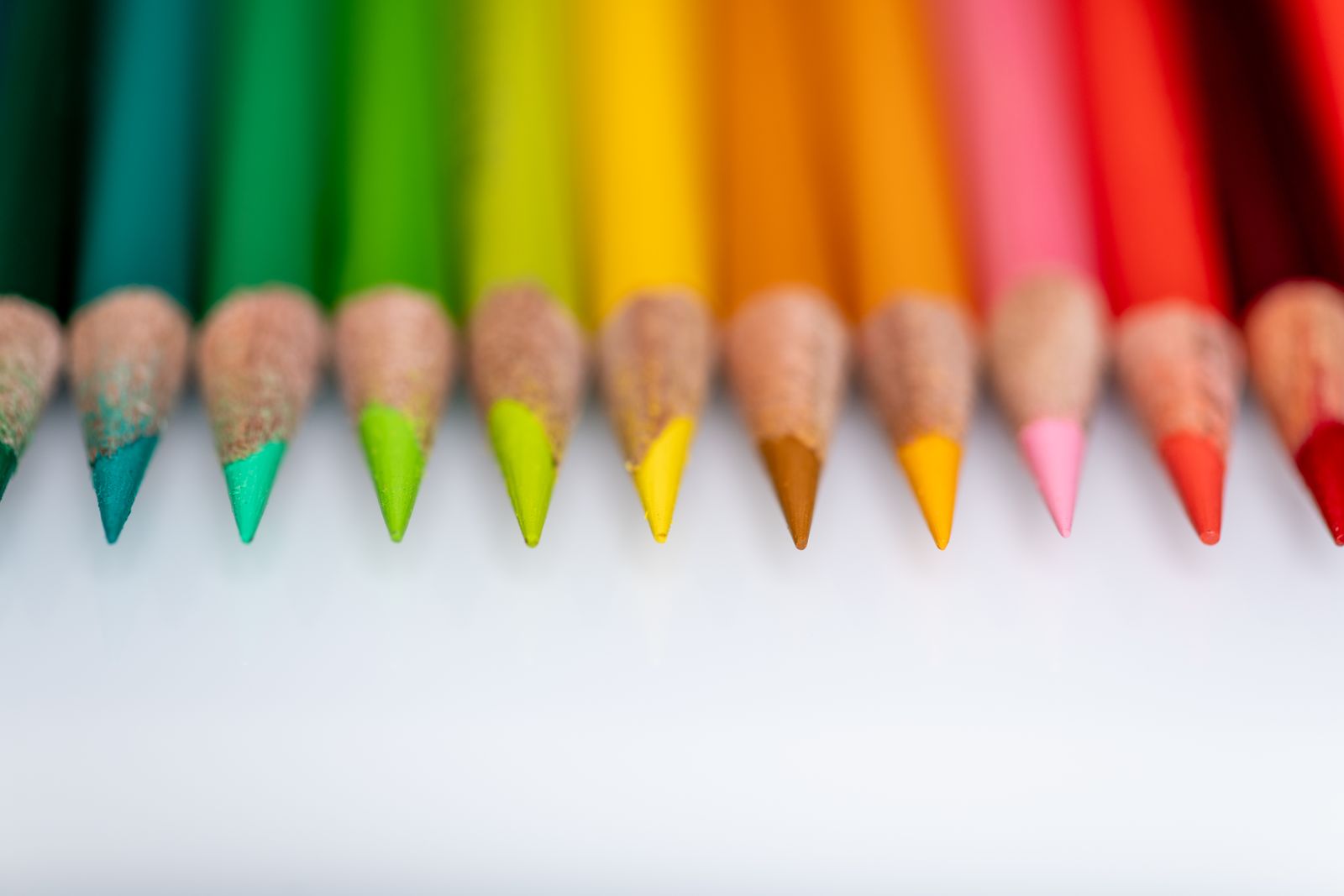 Sharpened colouring pencils arranged in a row on a pale table — photo by Skyler Ewing on Pexels