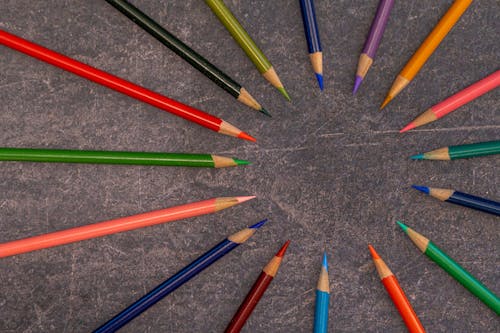 Multicolored pencils arranged on shabby table