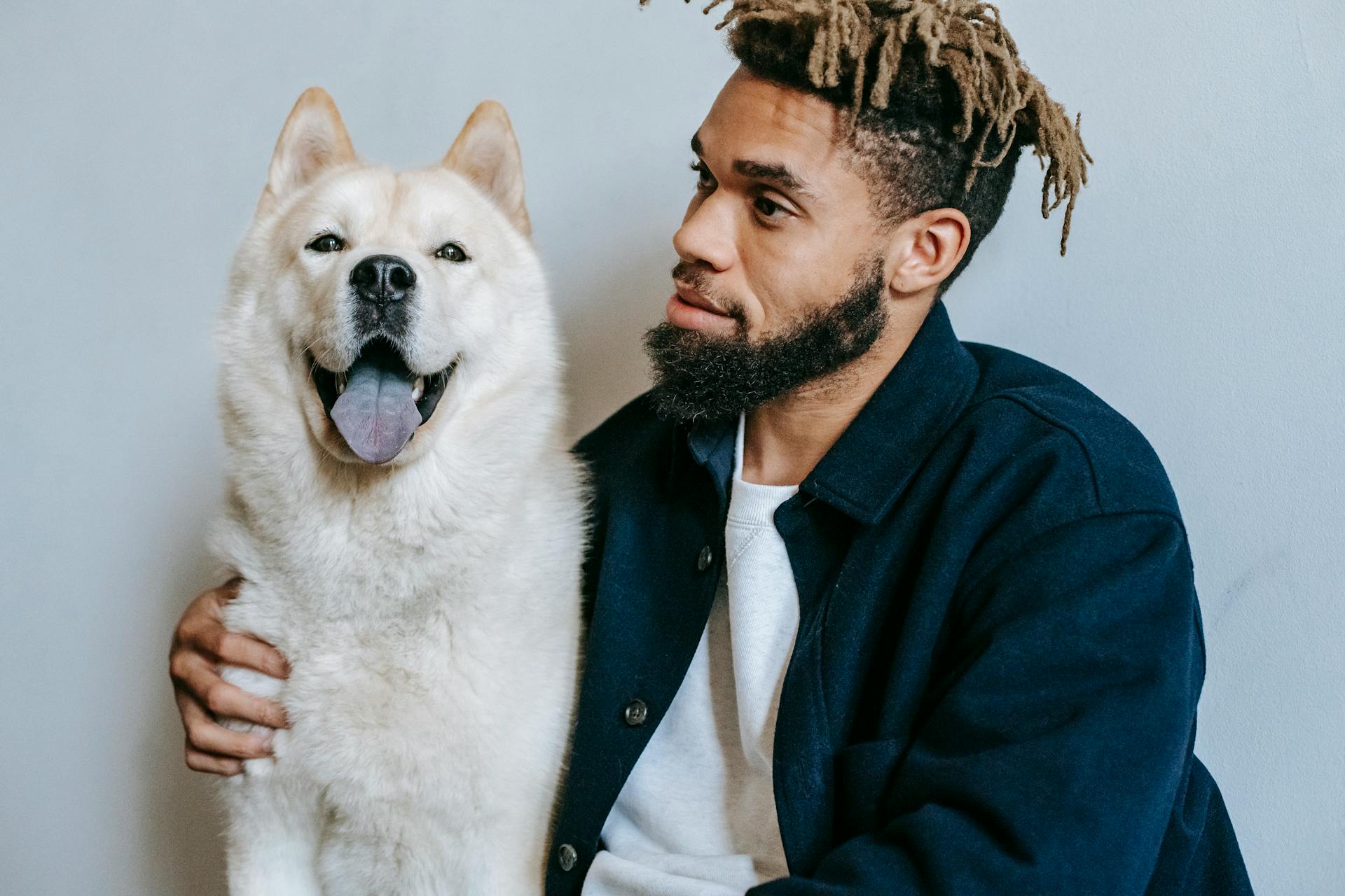 Een bedachtzame zwarte man met een Akita Inu-hond