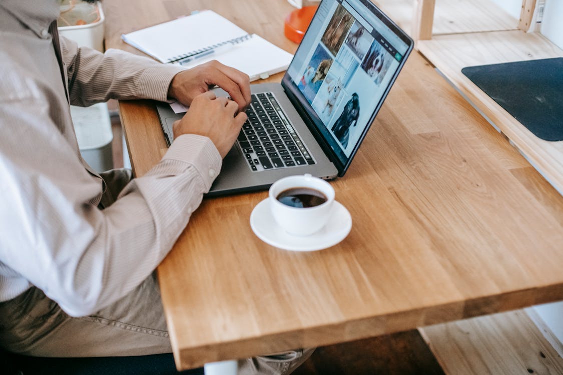 Osoba W Białej Koszuli Z Długim Rękawem Korzystająca Z Macbooka Pro