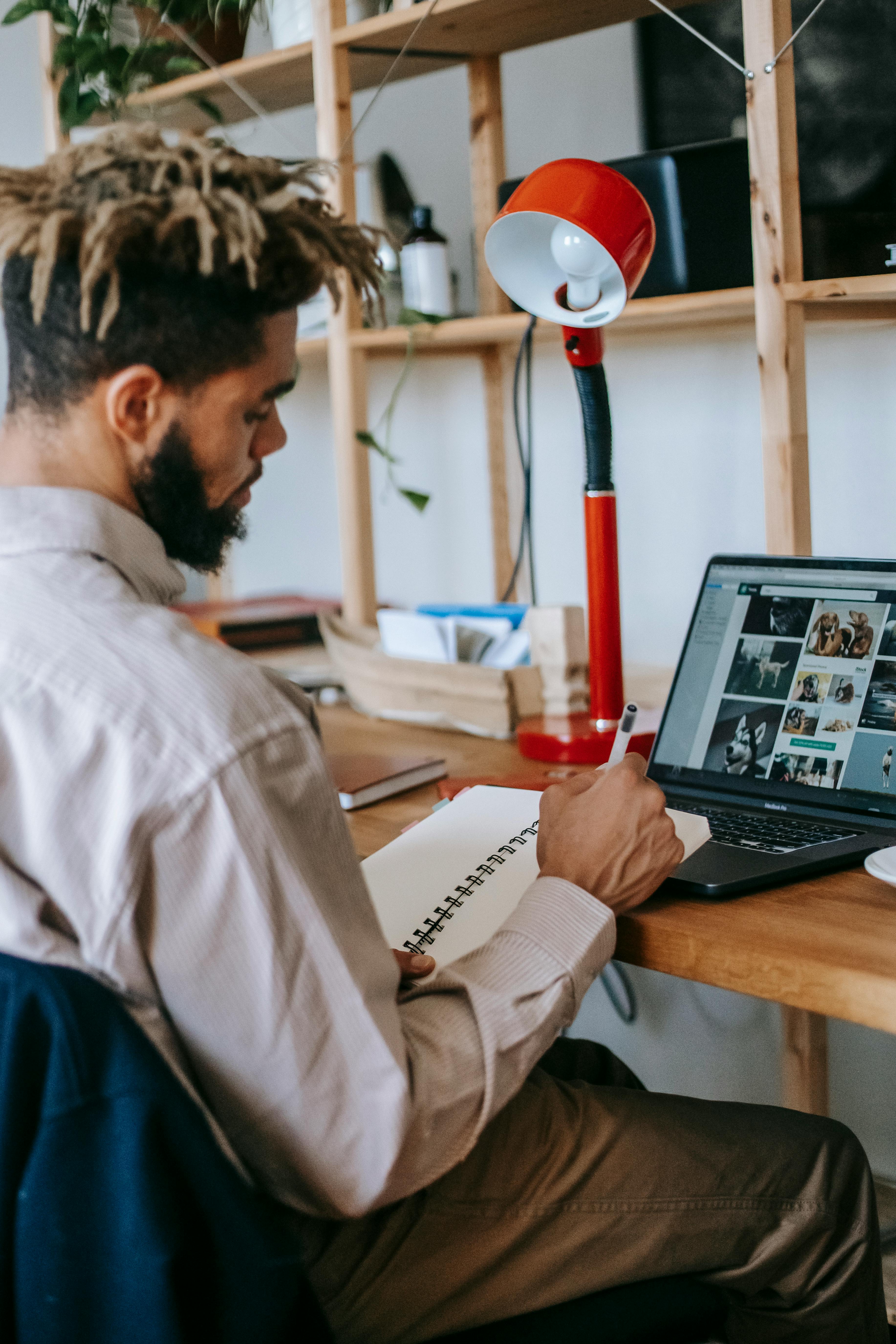 black guy working remotely on netbook in light workplace