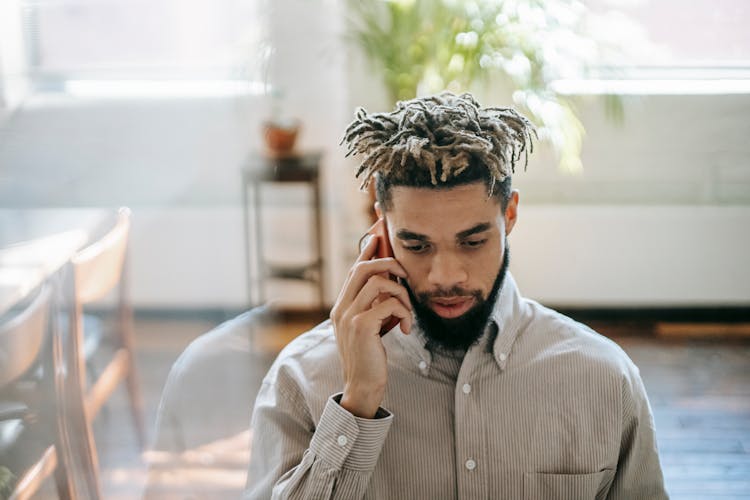 African American Male Talking On Phone In Office Room