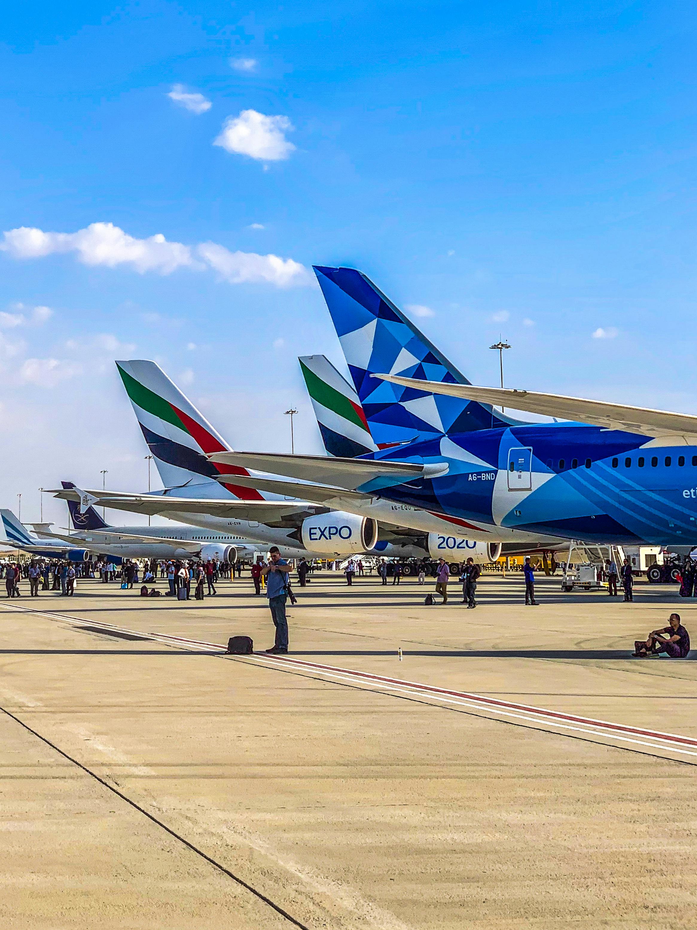 Free A lineup of airplanes on display at an airport runway during the day. Stock Photo