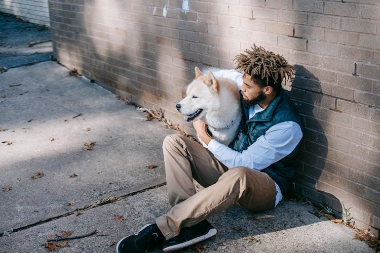 Young Man Sitting With White Dog