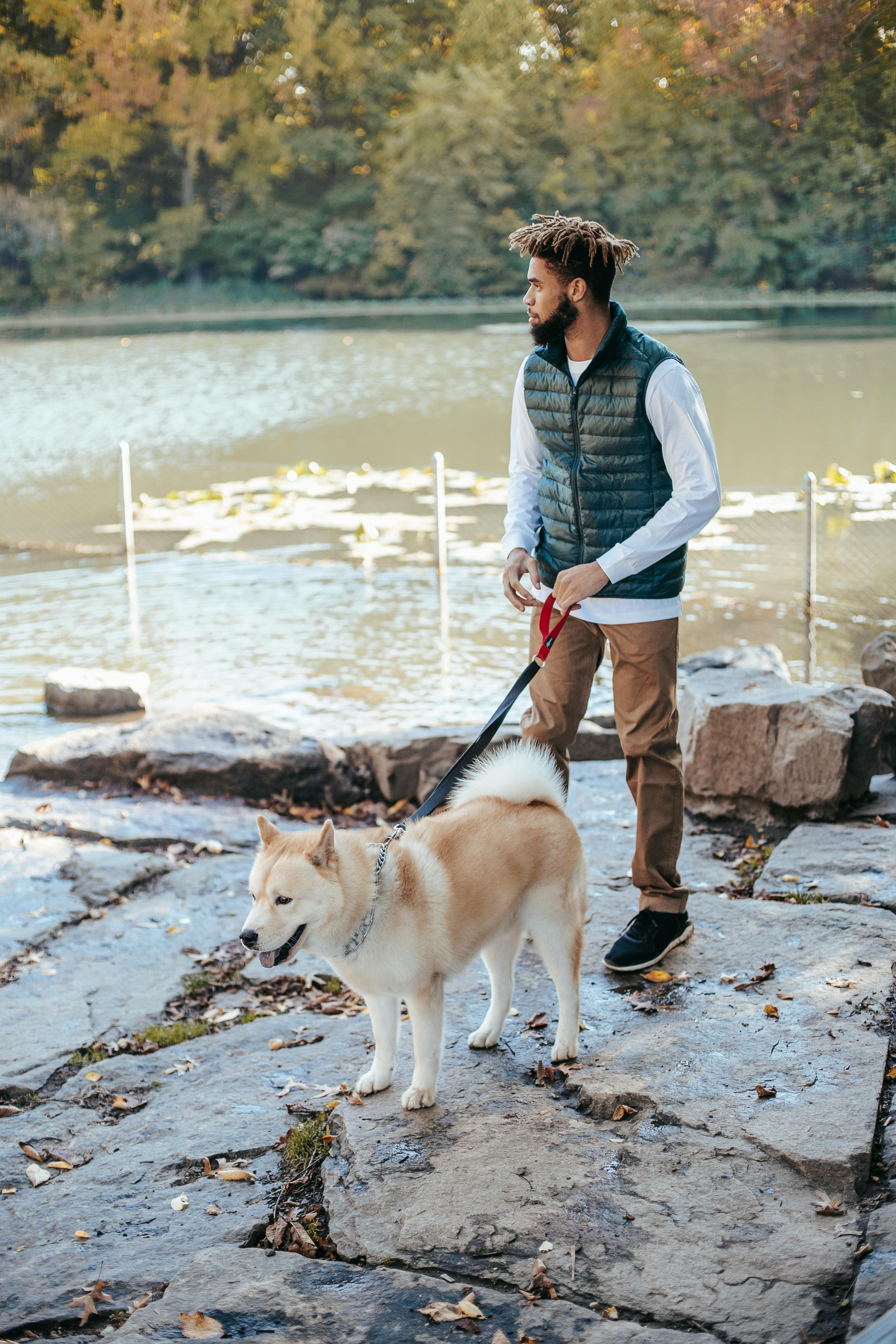 young man with dog near river