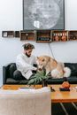 Young man with dog resting on sofa
