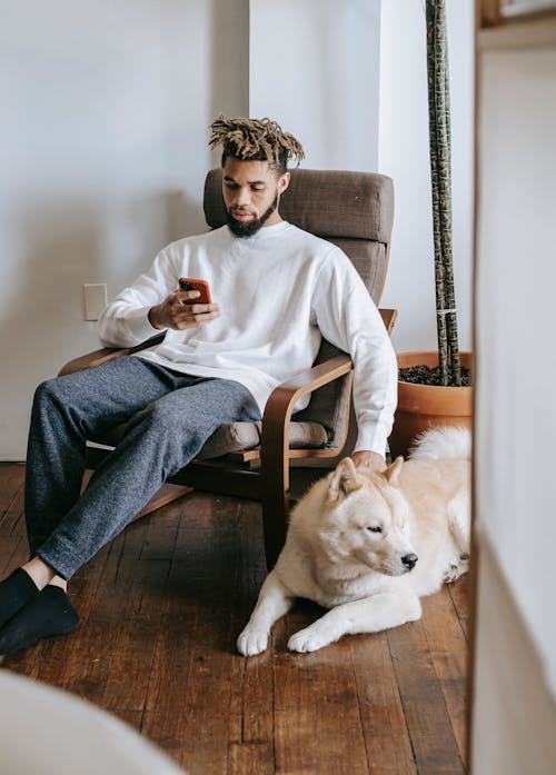 Free Man Sitting beside a Dog Stock Photo