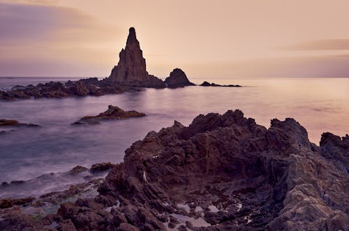 Brown Rock Formation on Sea during Sunset