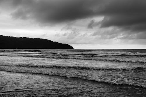 Grayscale Photo of Crashing Waves on Shore