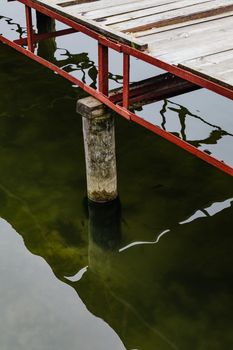 平静的水面上，一座木码头的倒影被捕捉在一个宁静的场景中