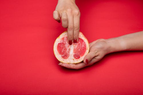 A Person Holding a Sliced Fruit