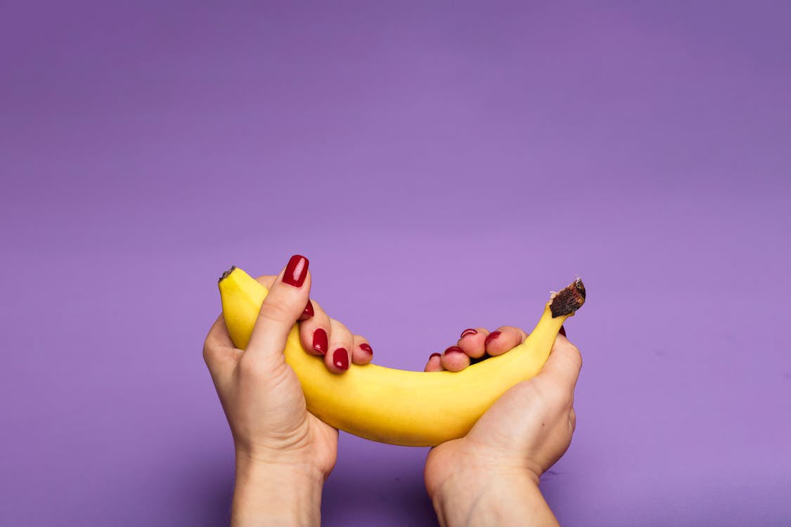 Free Person Grasping a Banana Stock Photo