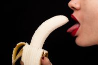 Person Holding Banana With Tongue Out