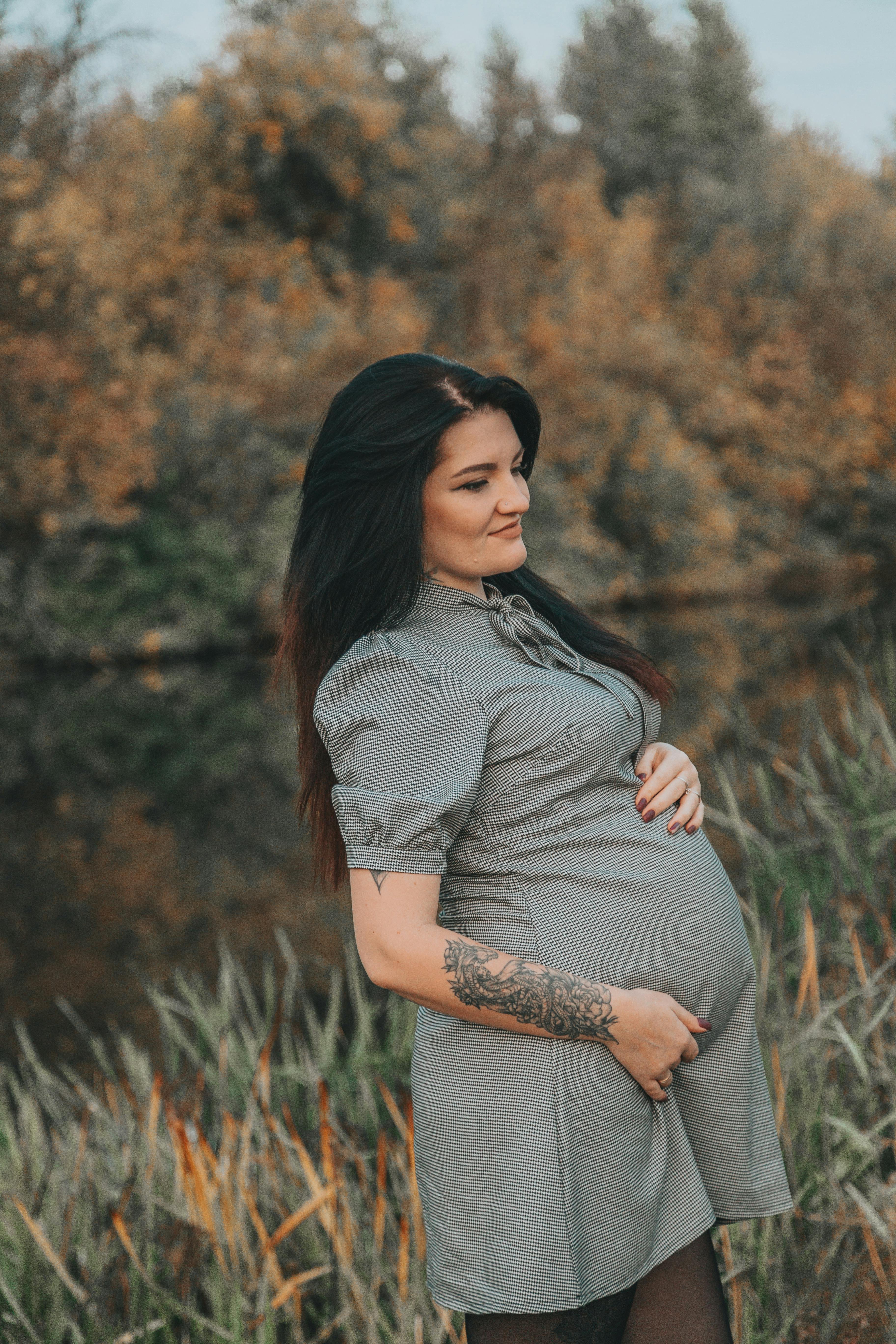 pregnant woman standing on river bank