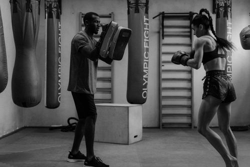 Free A boxer practicing with a trainer using focus mitts in a gym setting. Stock Photo