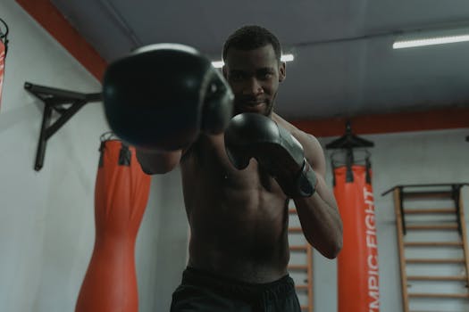 Focused boxer trains in gym, demonstrating strength and agility.