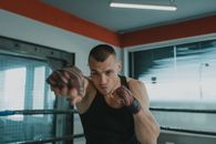 一位坚定的男性拳击手在室内戴着手铐练习太极拳