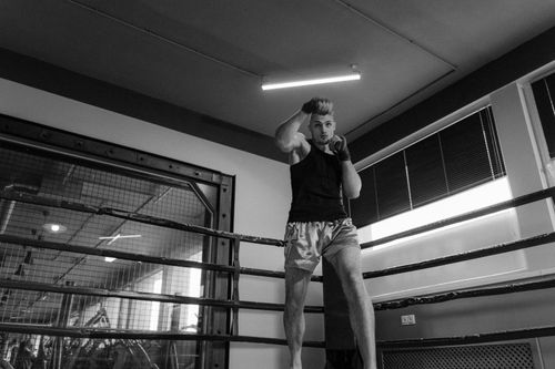 Free A muscular boxer practices shadow boxing in an indoor gym, emphasizing fitness and strength. Stock Photo